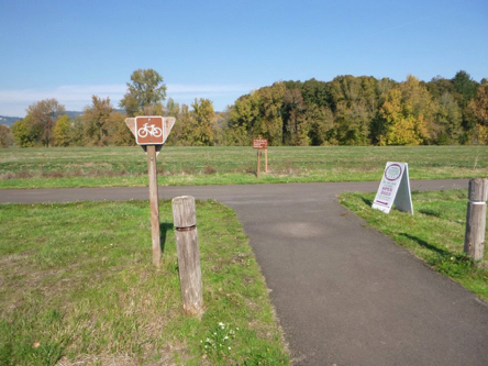 Trail from the visitor center goes across bike path &ndash; sign for bike trail - sign for visitor center store