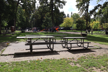 Four picnic tables, one with accessible extended end, located on concrete slab near playground – with grill – may have a lip Four picnic tables, one with accessible extended end, located on concrete slab near playground – with grill – may have a lip