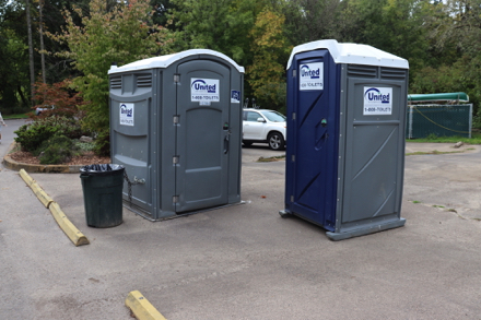 Parking lot at non-motor boat launch has a river map, two porta-potties, covered picnic shelter and garbage