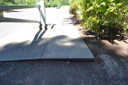 Sidewalk without transition ends at the park entrance &ndash; sidewalk drops onto driveway