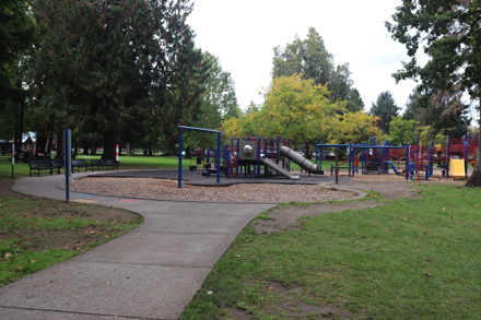 Children's playground with bark chip and mat surface &ndash; partial sidewalk &ndash; playgrounds in two locations