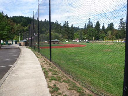 Sports field along entrance road with sidewalk and accessible restrooms