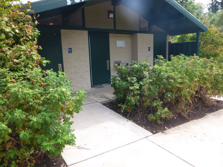 Concrete ramp to restrooms leads to a narrow walkway without edge protection