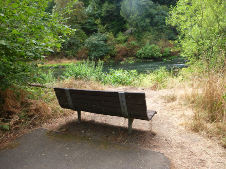 Transition from paved trail to natural surface with bench &ndash; may have a lip