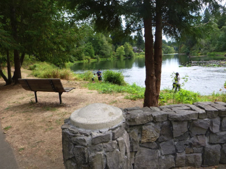 Bench on natural surface over-looks river &ndash; near interpretive displays and meteorite replica