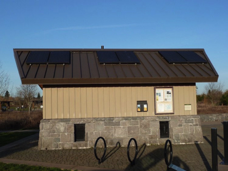 Solar panels on the restroom roof – sign on building explains benefits of solar energy Solar panels on the restroom roof – sign on building explains benefits of solar energy