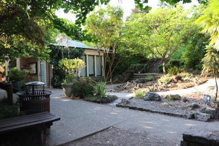 Garden space, bench and trash can near Visitor Center &ndash; stairs and ramp to parking lot