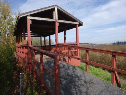 Shelter that overlooks wetlands &ndash; wooden railings &ndash; ramp with compact gravel transition to wooden surface