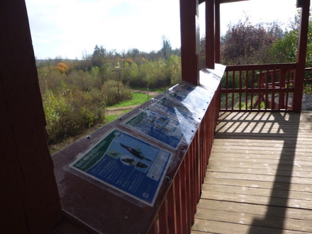 Interpretive displays along the railing of shelter &ndash; wooden deck &ndash; view of refuge