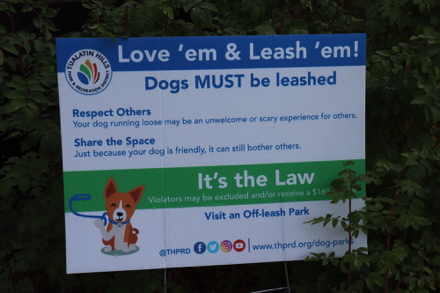 Dogs must be on leash &mdash; sign says: Love&rsquo;em & Leash&rsquo;em!