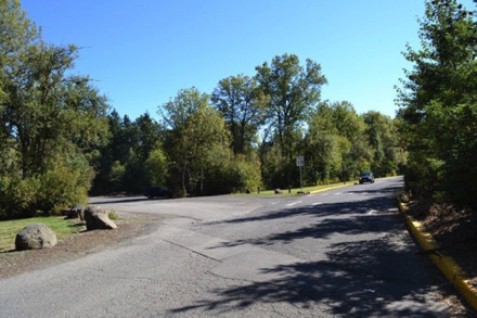 Main road into the park - gravel lot on the left for sports field and trail parking Main road into the park - gravel lot on the left for sports field and trail parking