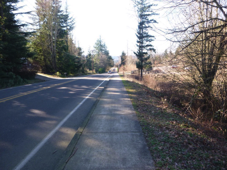 Steep grade of sidewalk between the bus stop and park
