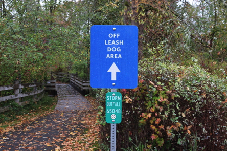 Off-leash dog area directional signage &ndash; hard surface to wooden bridge with railings