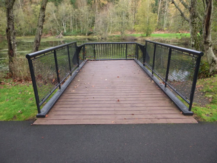 Overlook with railing at pond &ndash; transition from hard surface to wood at overlook