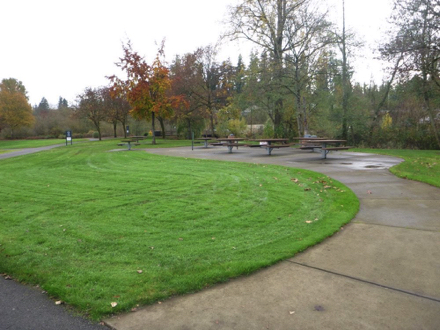 Hard surface path and under picnic tables &ndash; lawn &ndash; garbage can &ndash; information sign