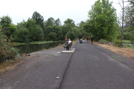 Wide paved trail along Turtle Pond &ndash; bench with companion seating area