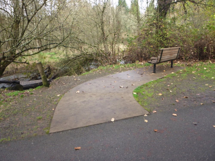 Hard surface trail &ndash; bench over looking Salmon Creek &ndash; gravel on the side of path