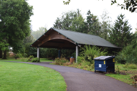 Covered picnic area off hard surface trail &ndash; picnic tables at shelter and on grass &ndash; trash can