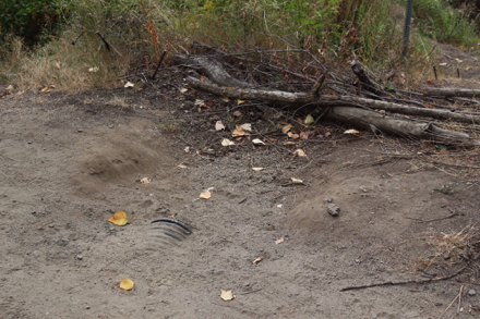 Rut in compacted gravel trail &ndash; corrugated pipe and logs on the side