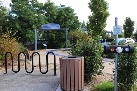 Entrance sign - hard surface trail - bike rack - garbage - dog waste bags - bench with arms - parking lot