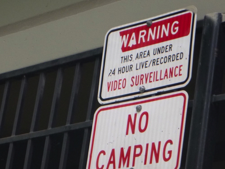 Sign under the freeway &ndash; no camping &ndash; warning, this area under 24 hour live/recorded video surveillance
